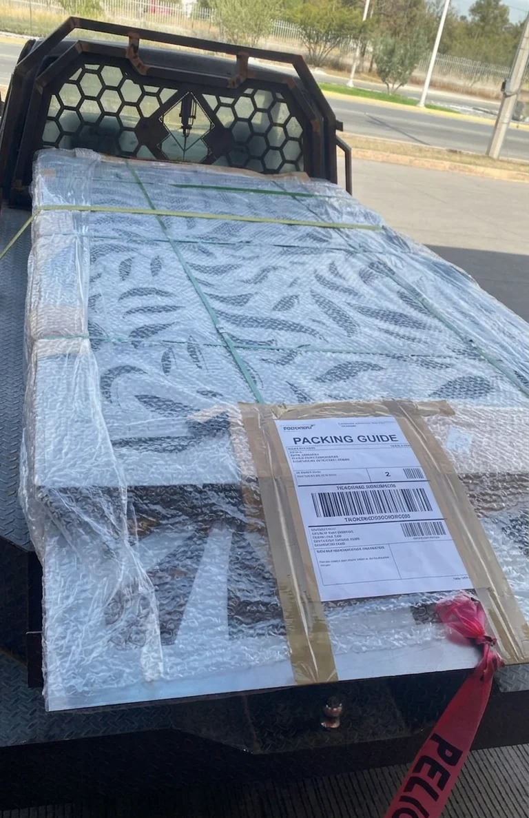 Celosía metálica empacada sobre camión con guía de paquetería para rastreo