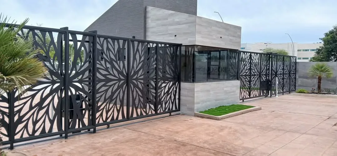 porton de celosia metalica negra con patron floral tipo sol en acceso comercial
