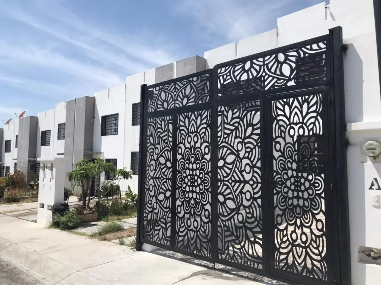 porton metalico de cochera con celosia de patron mandala floral en negro